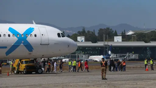 Personas caminan hacia el Centro de Recepción de Retornados tras arribar al país procedentes de los Estados Unidos en la base de la Fuerza Aérea Guatemalteca. ,EFE