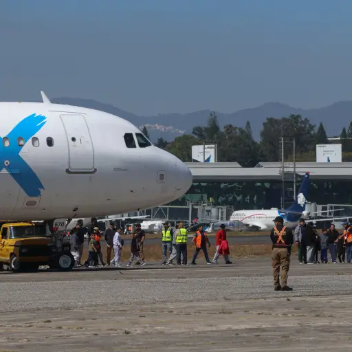Personas caminan hacia el Centro de Recepción de Retornados tras arribar al país procedentes de los Estados Unidos en la base de la Fuerza Aérea Guatemalteca. ,EFE