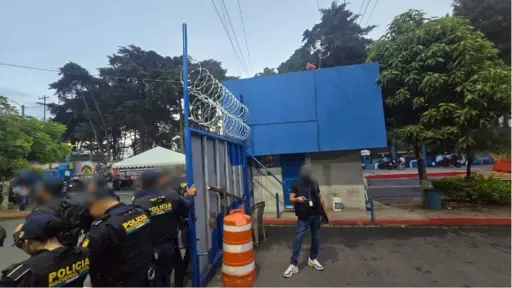 Agentes de la PNC resguardan el portón del ingreso a la USAC durante los allanamientos. ,Ministerio Público.
