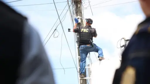 Varios agentes suben a lo alto de los postes para retirar las cámaras instaladas sin autorización. ,PNC de Guatemala.